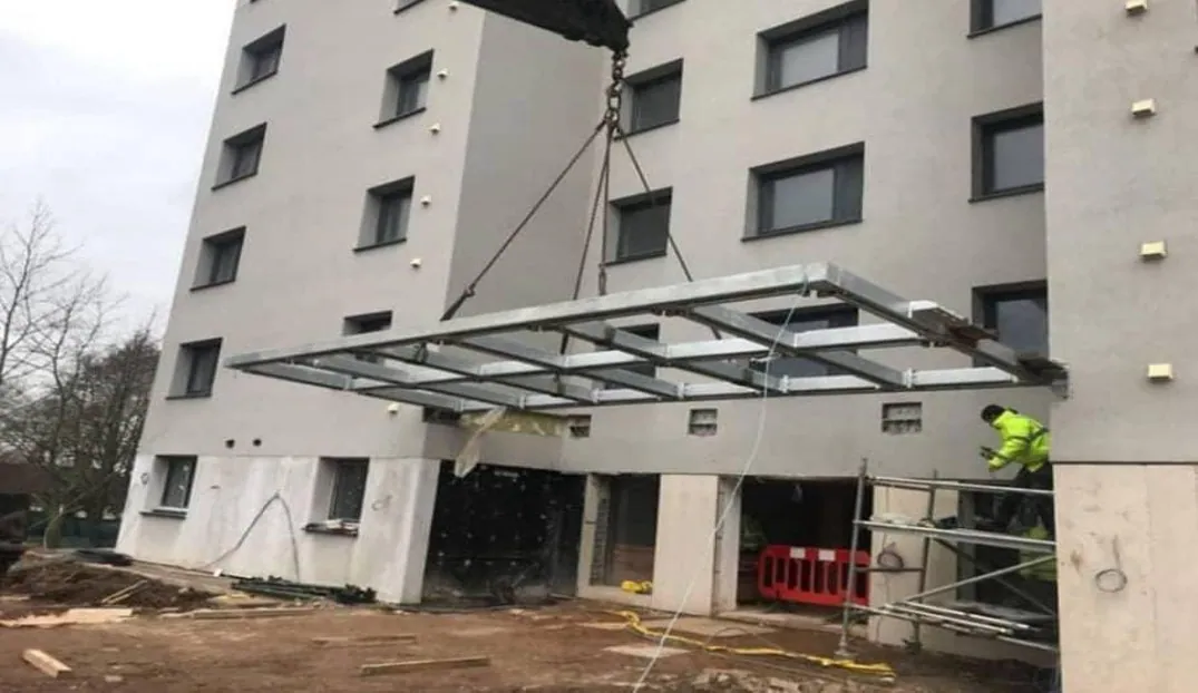 BUILDING SHADE — saçak montajı sırasında yapı girişi